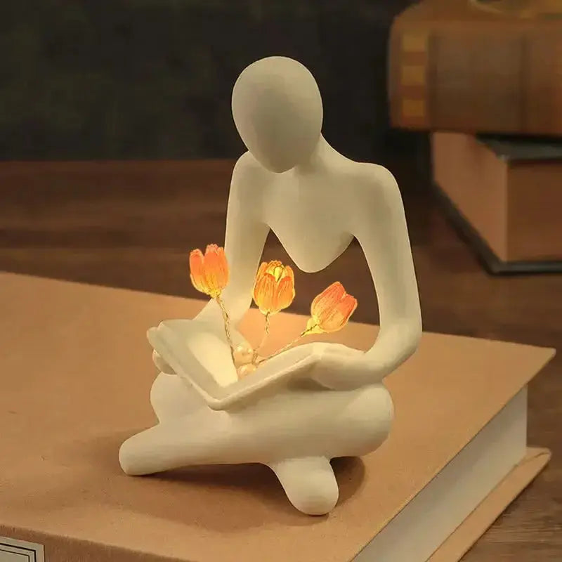 Estatueta Decorativa Pessoa Lendo com Flores Iluminadas Casamarella