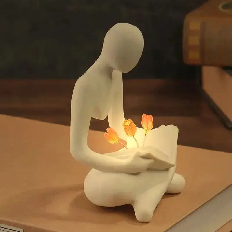 Estatueta Decorativa Pessoa Lendo com Flores Iluminadas Casamarella